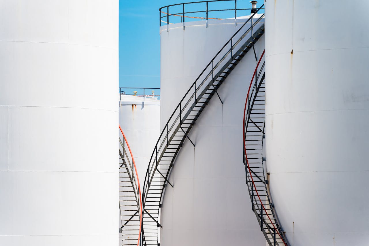 Vertical shot of large steel oil storage tanks with stairs in Antwerp, Belgium.